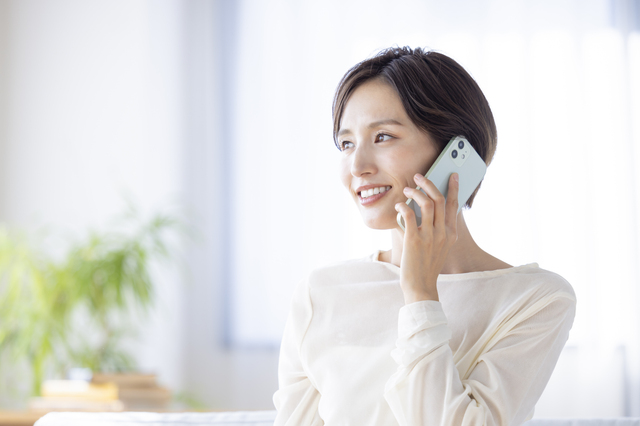 遠方から遺品整理業者に電話で相談する様子